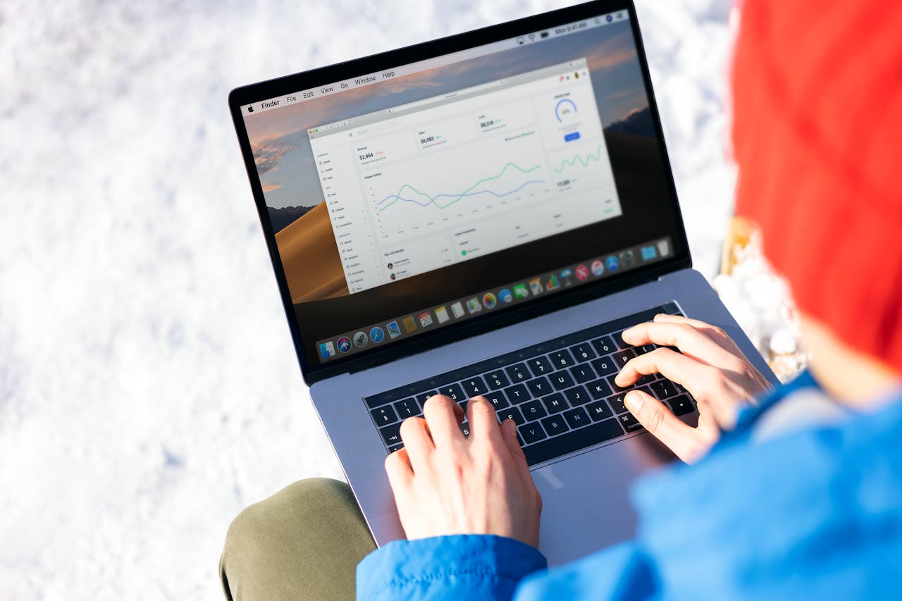 home-services-01 A person in a blue jacket analyzing business analytics on a laptop outdoors during winter.